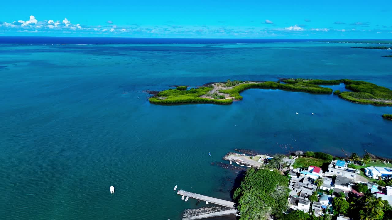 Wide aerial shot of ocean and island edge in Mauritius under bright daylight with clear sea below