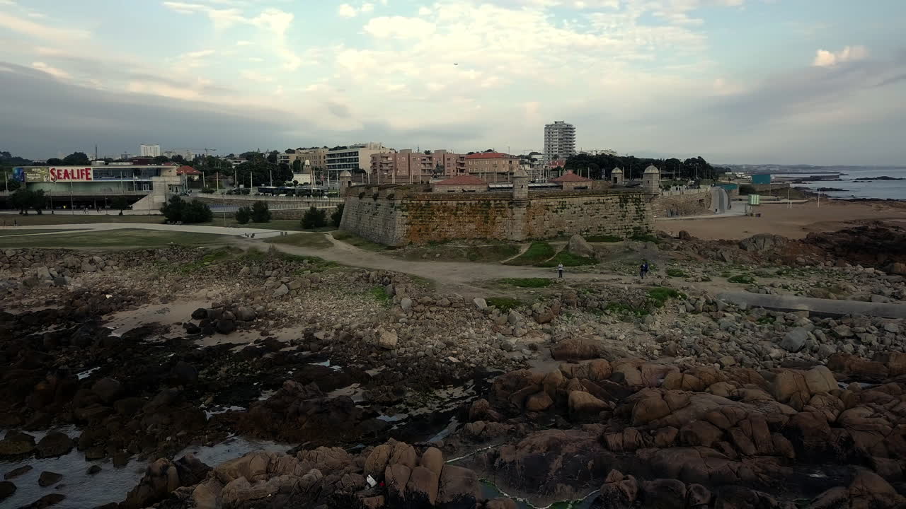Fortezza costiera in pietra che si affaccia sull'Oceano Atlantico in Portogallo, vicino a una spiaggia sabbiosa e a una costa rocciosa. Architettura militare storica e suggestivo paesaggio marino europeo.