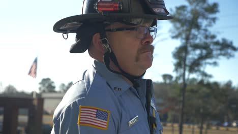 firefighter watches and listens during daily briefing at a fire station in the morning