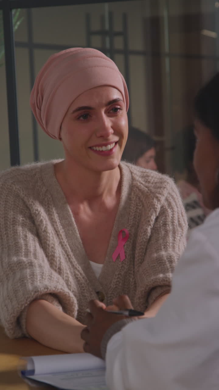 Vertical Video Of Young Woman Patient Wearing Headscarf Getting Good News At Meeting With Oncologist Or Doctor In Hospital For Breast Cancer Treatment 1