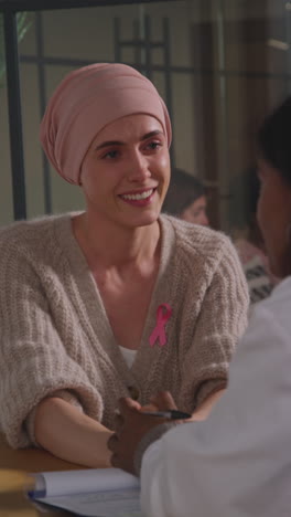 vertical video of young woman patient wearing headscarf getting good news at meeting with oncologist or doctor in hospital for breast cancer treatment 1