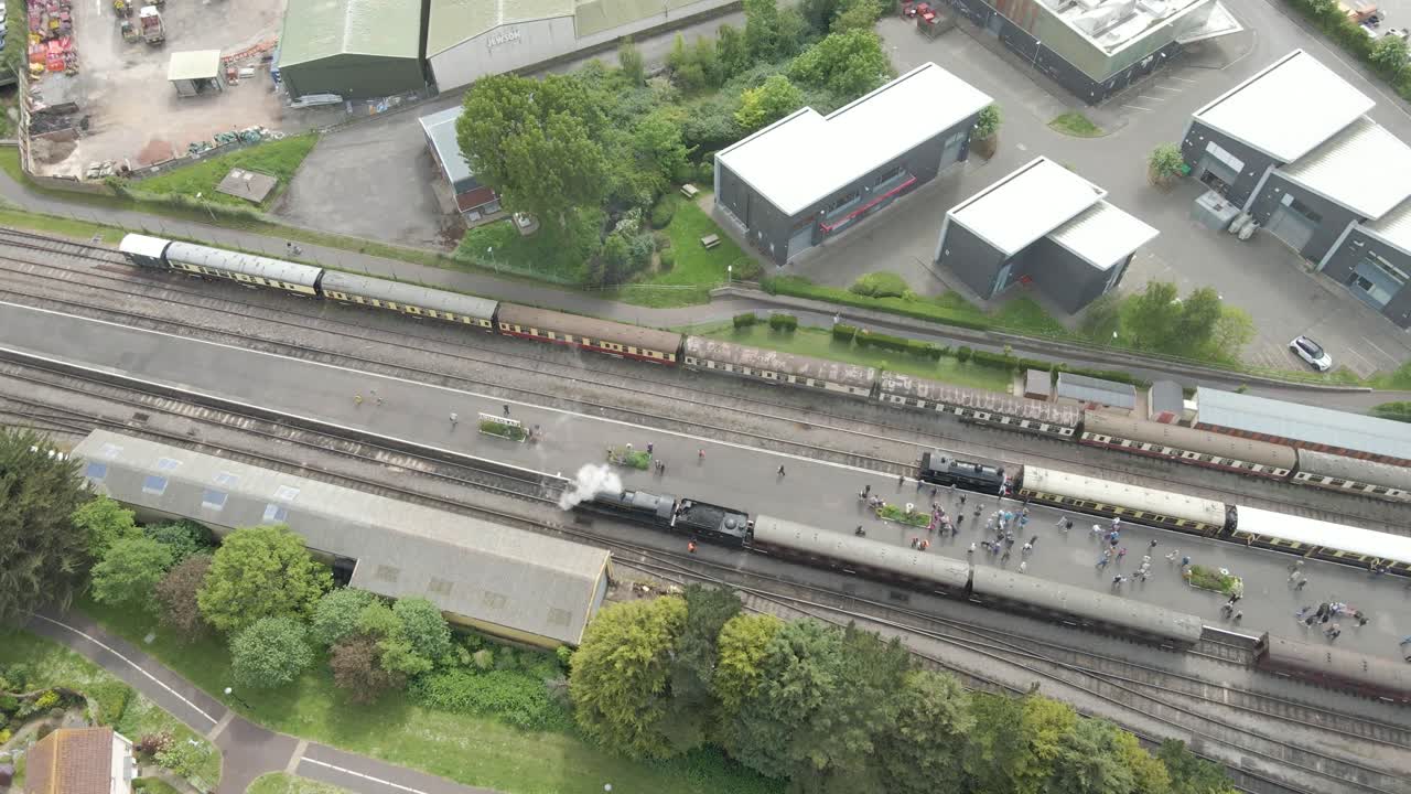 Aerial view of the Minehead steam railway station England's longest heritage line, running 20 miles between Minehead and Bishops Lydeard. Drone rotating to the left over one of steam train