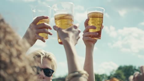 group of caucasian friends make toasting beer at festival