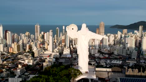 vista aérea de cristo el redentor en balneario camboriu con la ciudad y la playa en el fondo