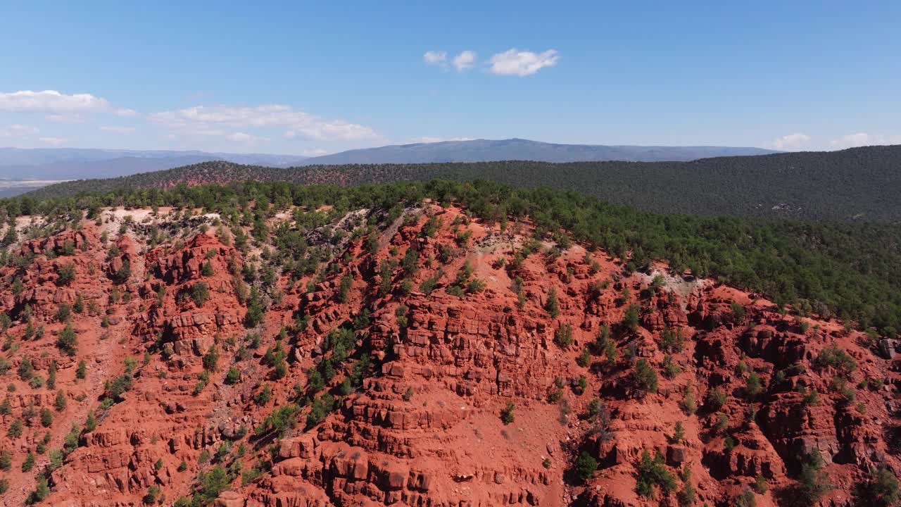 High aerial pullback of vibrant red formations at Mushroom Rock with bright daylight accenting rugged texture, Carbondale Colorado