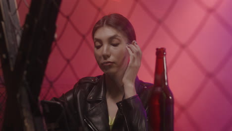 Beautiful-Girl-In-Leather-Jacket-Holding-Mobile-Phone-And-Enjoying-Music-At-Disco