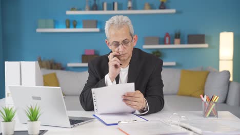 home office worker man examining, analyzing documents.