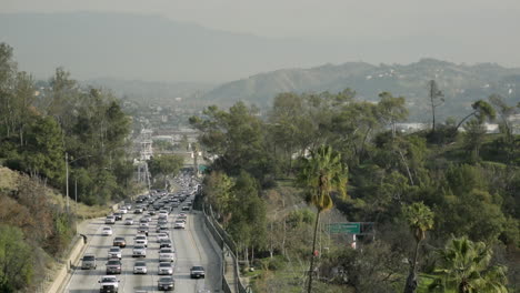 a busy california highway at rush hour on a sunny day.