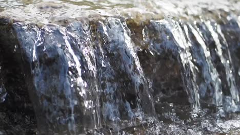 close up of water flowing over rocks