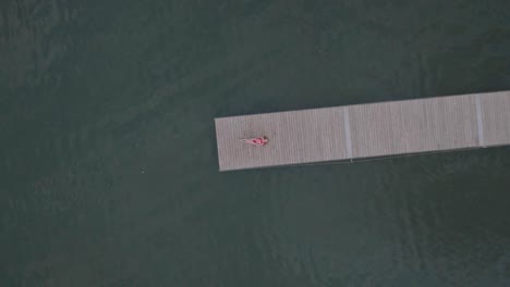 aerial rocket shot of the young women enjoying a summer day on a dock