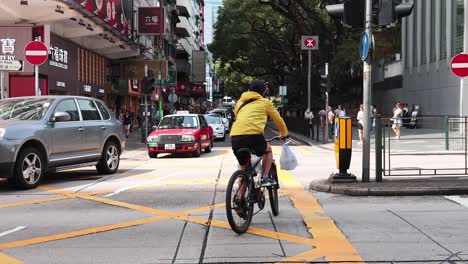 cyclist and cars navigate bustling city intersection