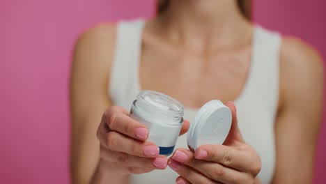 woman holding a jar of cream