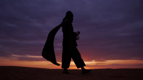 woman in desert at sunrise/sunset silhouette
