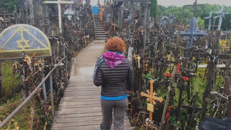 a shot following a woman in hill of crosses, lithuania