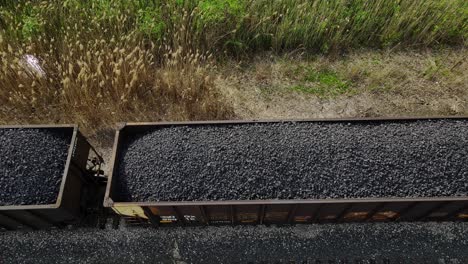 coal train with resources driving on tracks, aerial downwards view