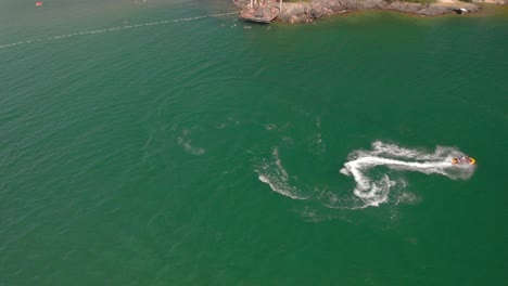 drone volando sobre jetski en el mar de agua verde