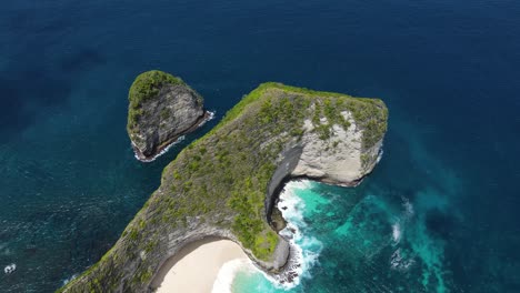 drone footage of kelingking beach, nusa penida, showcasing stunning cliffs, crystal-clear waters, and the iconic t-rex shape