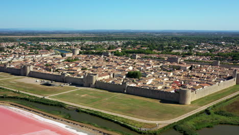 aigues-mortes 是一個歷史悠久的城市,位於法國卡馬爾古省,在一個陽光明<unk>的夏天,靠近一個粉紅色的盐湖.