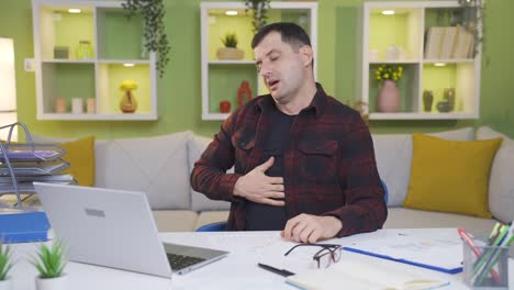 hombre cansado y agotado trabajando desde casa se duerme en la mesa.
