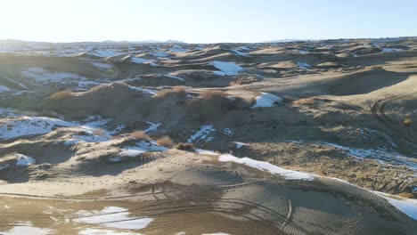 Scenic-aerial-views-of-sand-dunes-in-Utah,-USA-with-snow-patches-in-the-winter