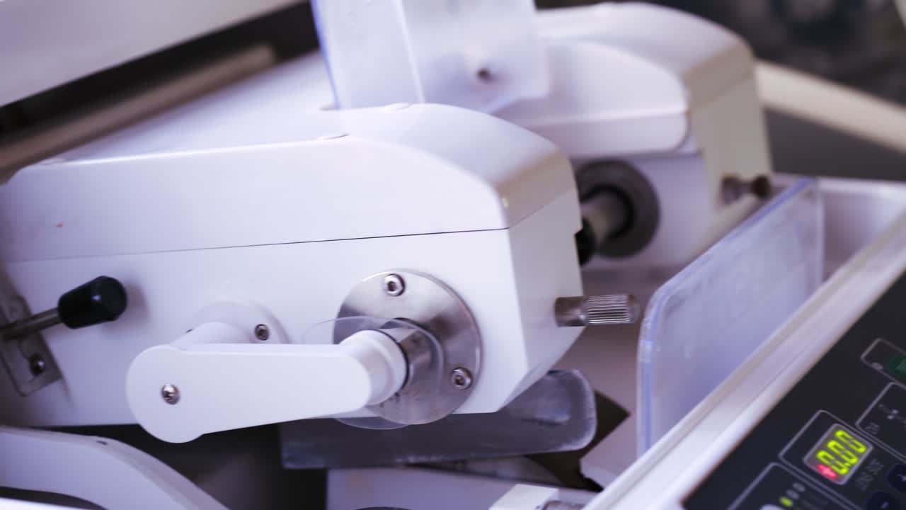 Optician repairing eyeglasses. Optician measuring and preparing glasses on the latest digital device in optical store