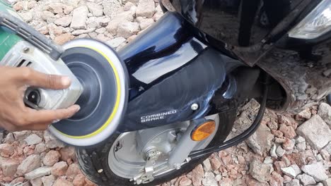 Close-up-shot-worker-rubbing-polish-moped-Motorcycle-bike-Mudguard-Front---with-special-tools-indoor