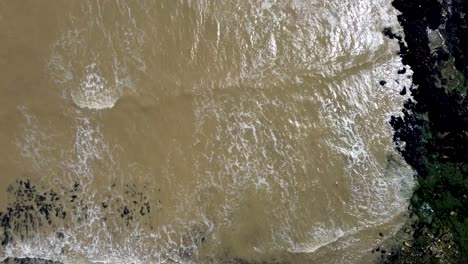video de drones sobre la cabeza imágenes de 4k de olas que vienen sobre las rocas