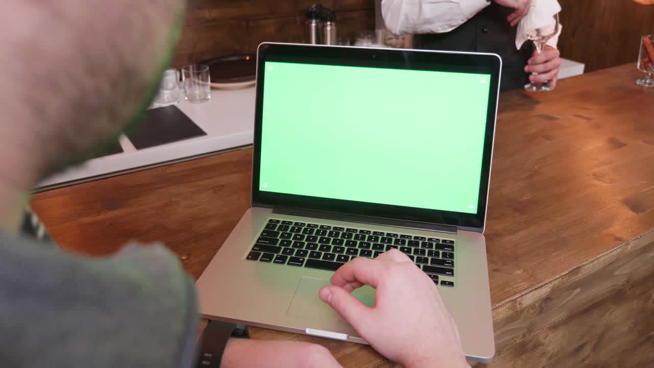 Laptop with green screen in a bar