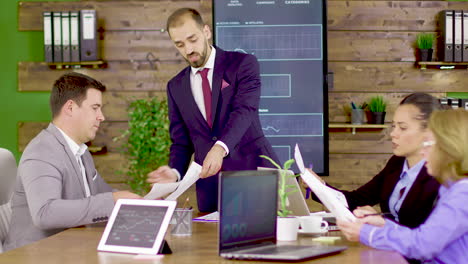 bearded businessman in suit giving his team to analyze charts