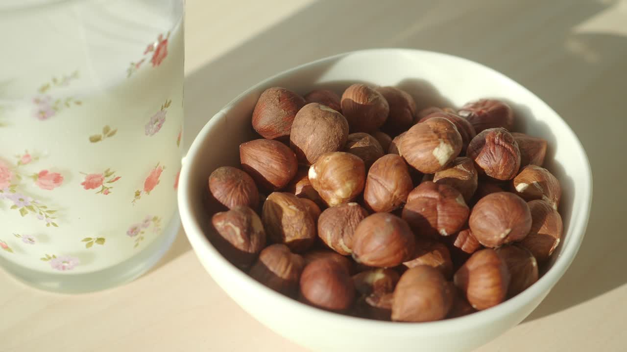 Nocciole in una ciotola con un bicchiere di latte