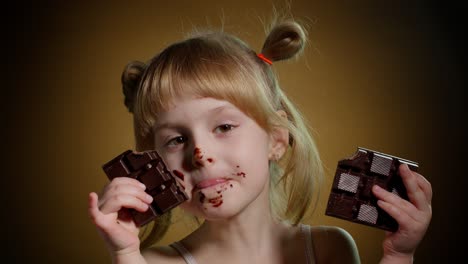 satisfied teen child kid girl holding chocolate bars, making faces, smiling, showing tongue