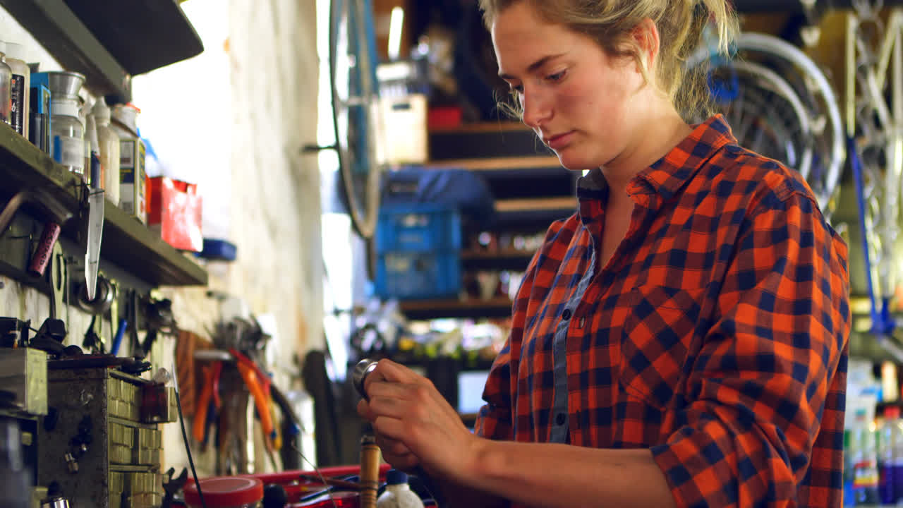 Donna che regola un attrezzo in officina 4k