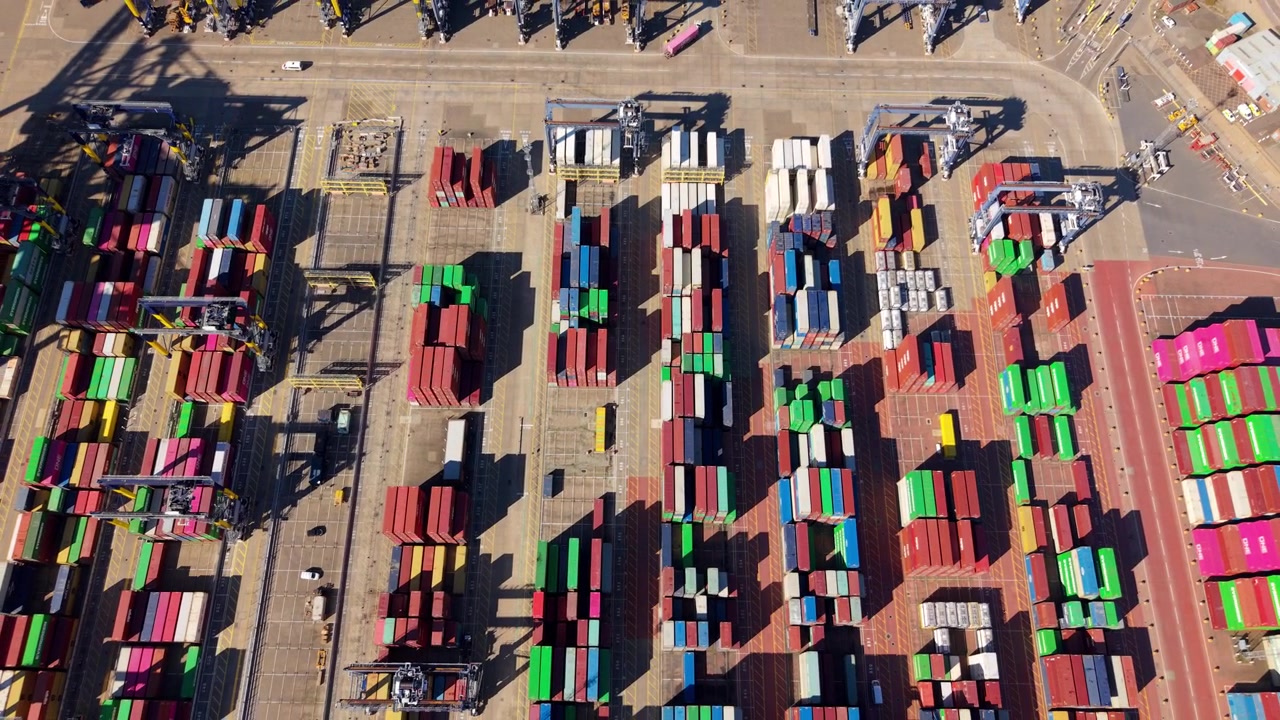 Forward drone flight over ultra large container ships handling import export cargo at Felixstowe Port UK