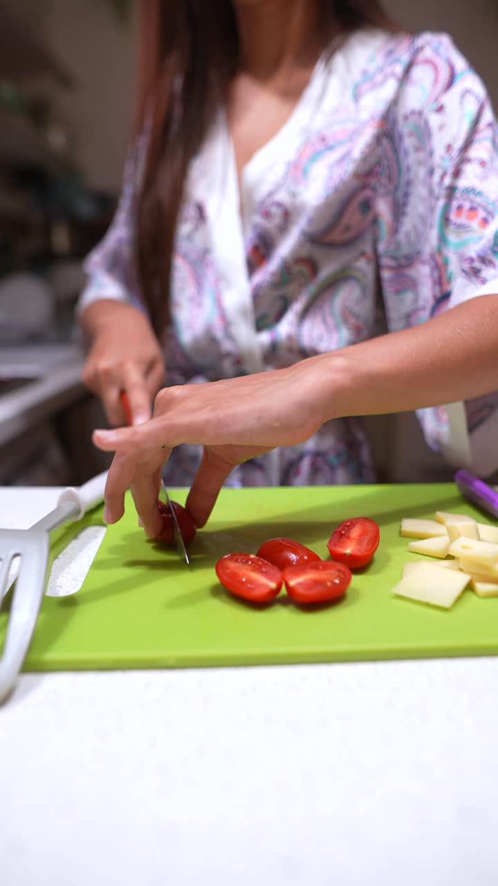 mujer preparando una ensalada con tomates y queso