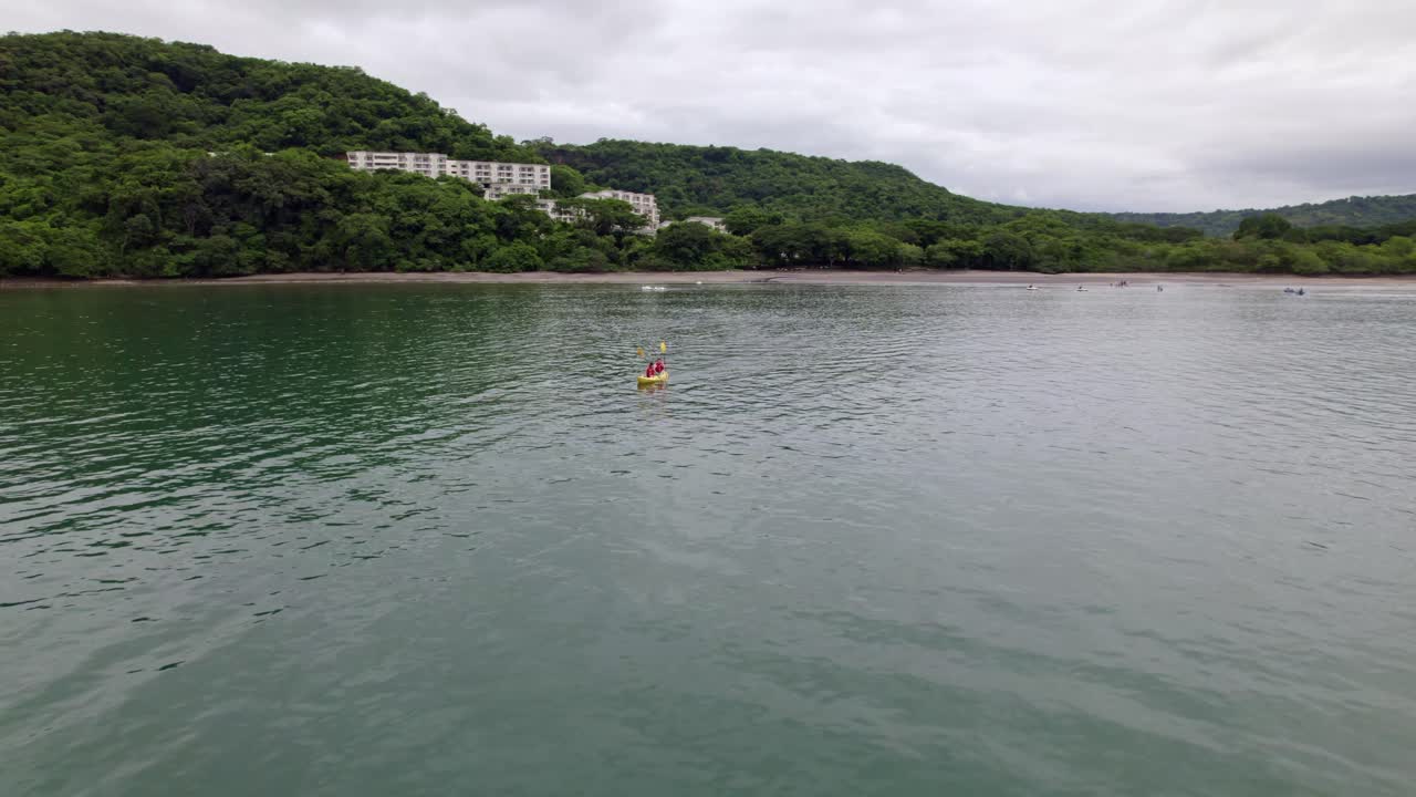 muñeca aérea de personas haciendo kayak cerca del hotel planet hollywood entre bosques, playa de nacascolo, península de papagayo, costa rica