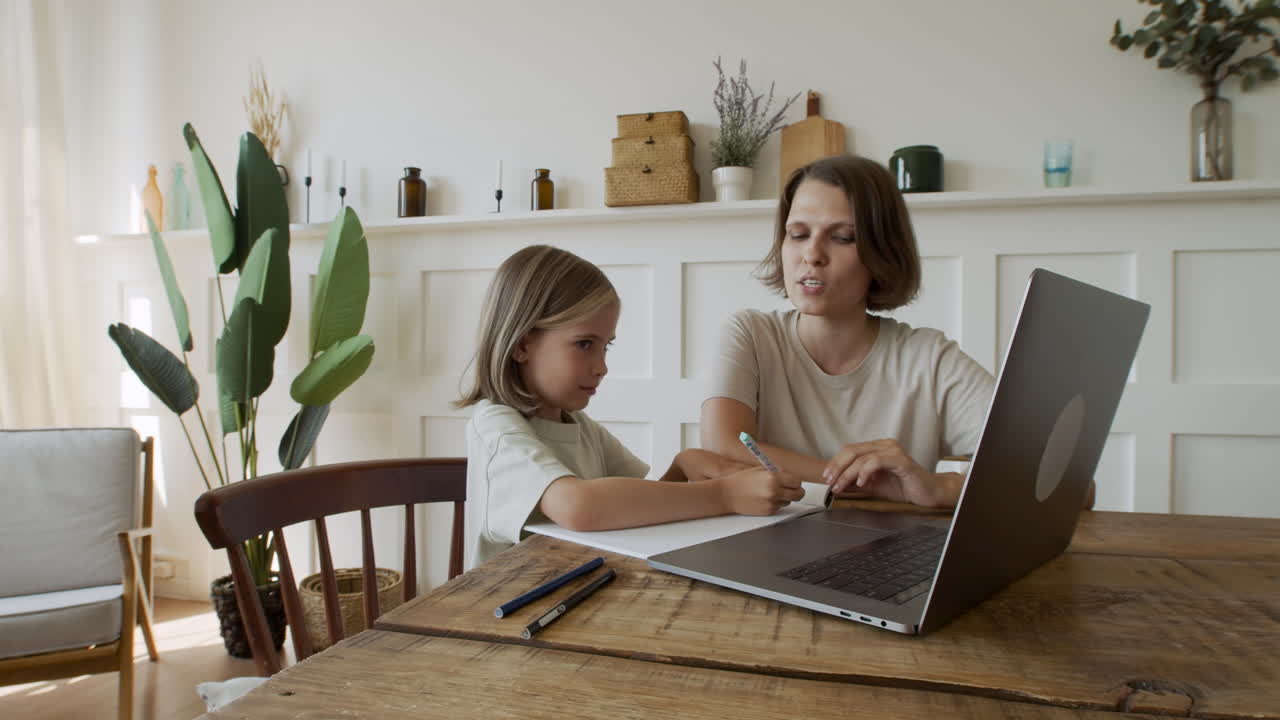 joven sonriente vestido con estilo apoyado contra la pared en la calle, tocando y desplazándose mientras conversa en el teléfono inteligente