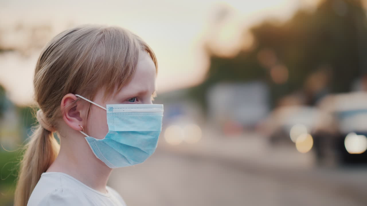 un niño con una venda de gasa protectora se encuentra cerca de una carretera polvorienta problemas de salud y ecología