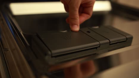 Close-up-shot-of-a-man-putting-a-detergend-pad-in-the-dishwasher-compartiment