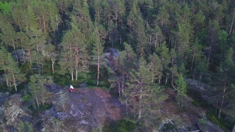 Skilled-mountainbiker-biking-over-rocks-and-roots-on-drone-footage