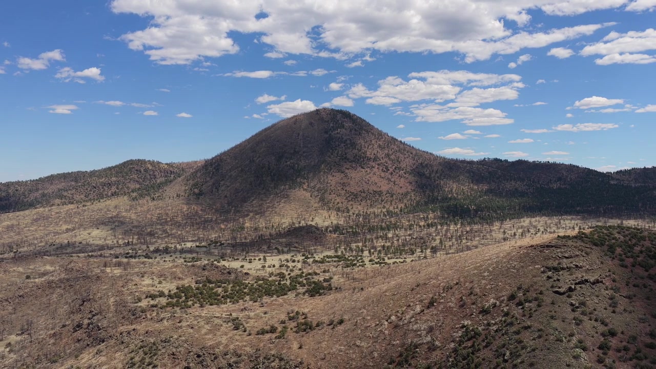 Questa vista cinematografica da drone mette in risalto il picco O'Leary, una montagna vulcanica vicino a Flagstaff, Arizona. Lo scenografico paesaggio del sud-ovest presenta fitte foreste di pini e una cima aspra di deserto d'alta quota.