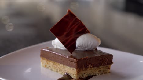 slow-rising shot of a chef finishing off a chocolate dessert ready to be served