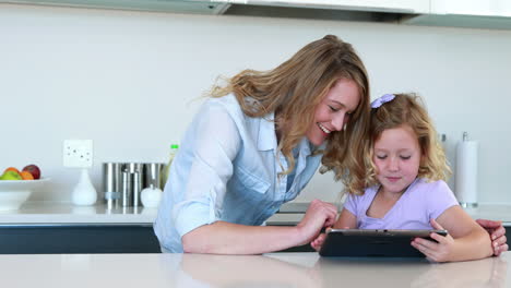 little girl using a digital tablet with her mother