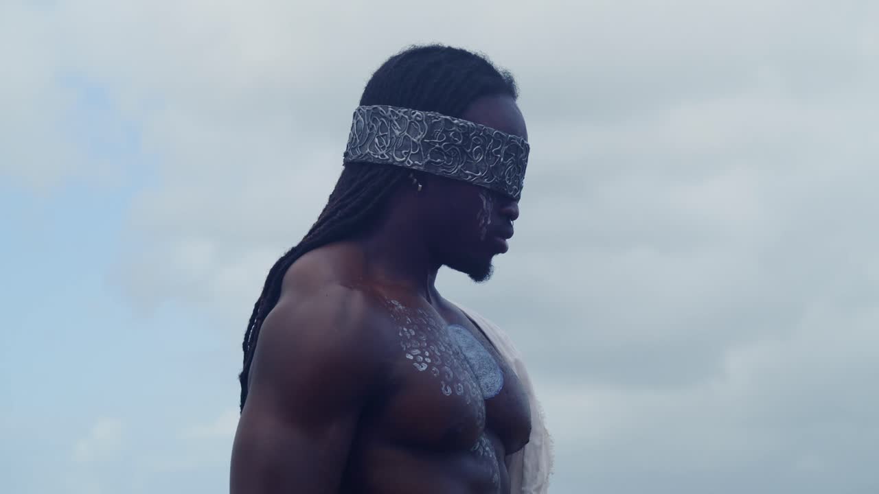 Perfectly in character as Nekharis cosplay, a muscular, dark-skinned man is at a tropical beach
