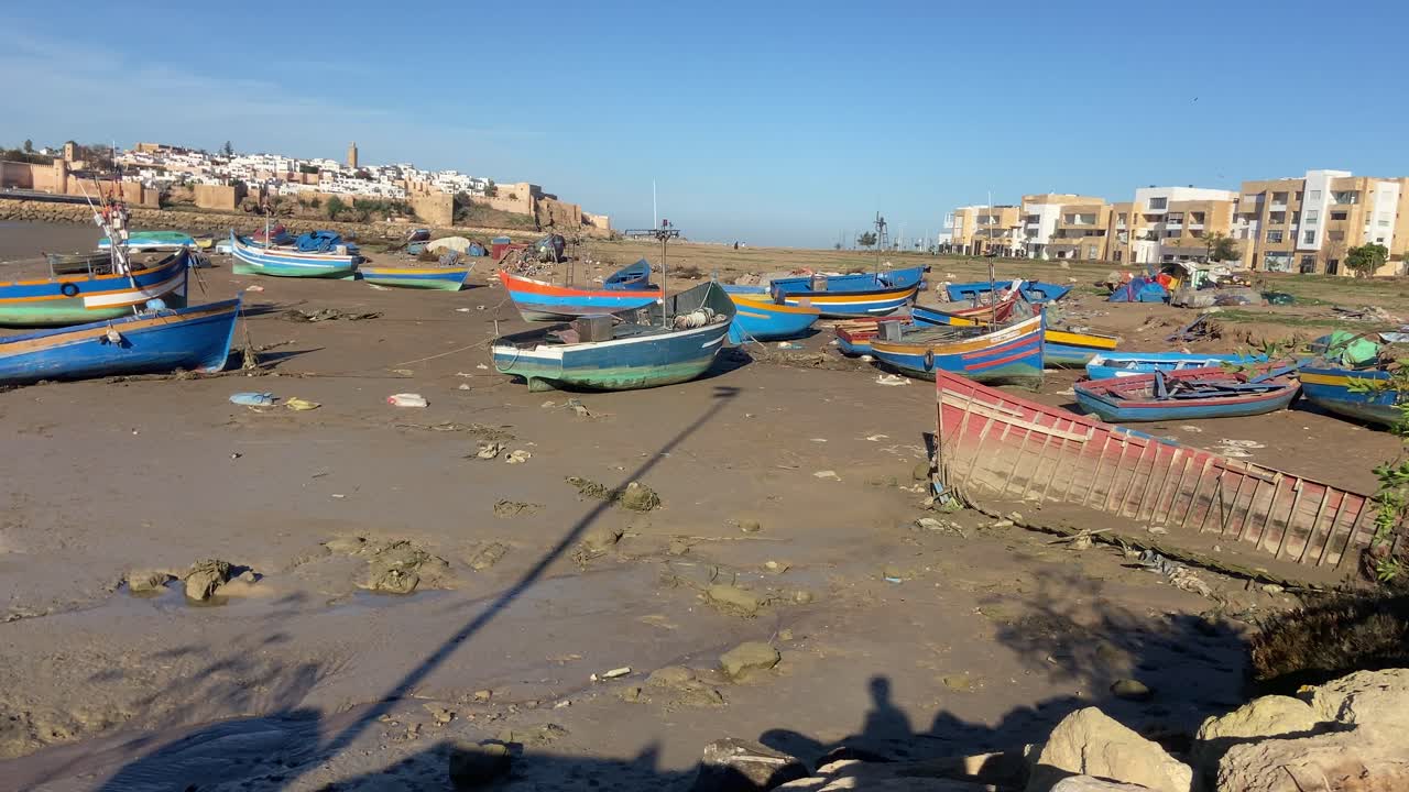barcos de madera rústicos amarrados en la arena en las orillas del río rabat bou regreg