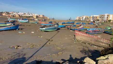 rustic wooden boats moored on the sand on rabat bou regreg riverbanks