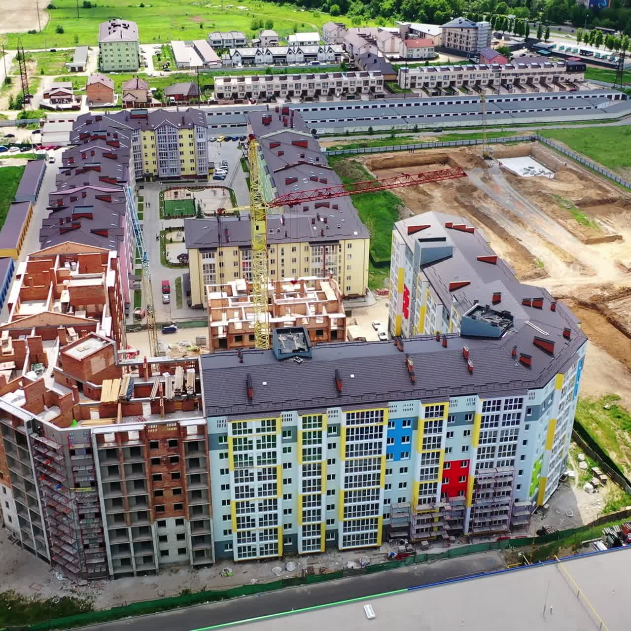 Modern construction area in the city. New residential complex is building in summer. Tower crane in a construction site