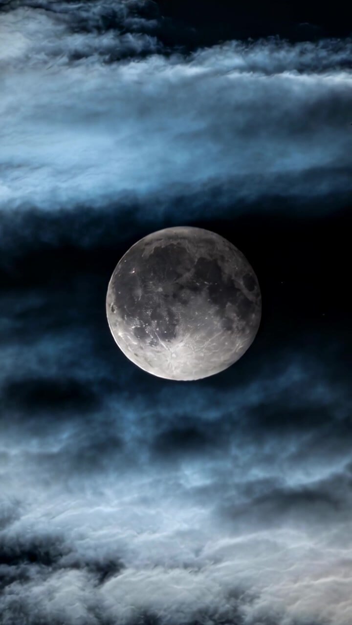 Vídeo vertical: Nuvens à deriva velando lentamente a lua quase cheia em quadro vertical, revelando a superfície