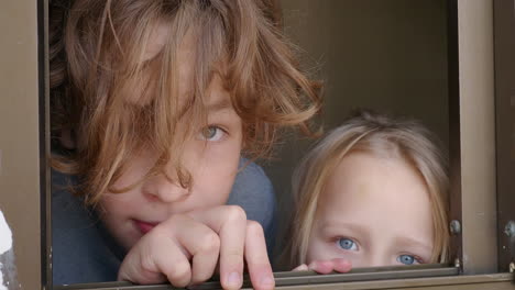 Bruder-Und-Jüngere-Schwester-Schauen-Aus-Dem-Offenen-Fenster