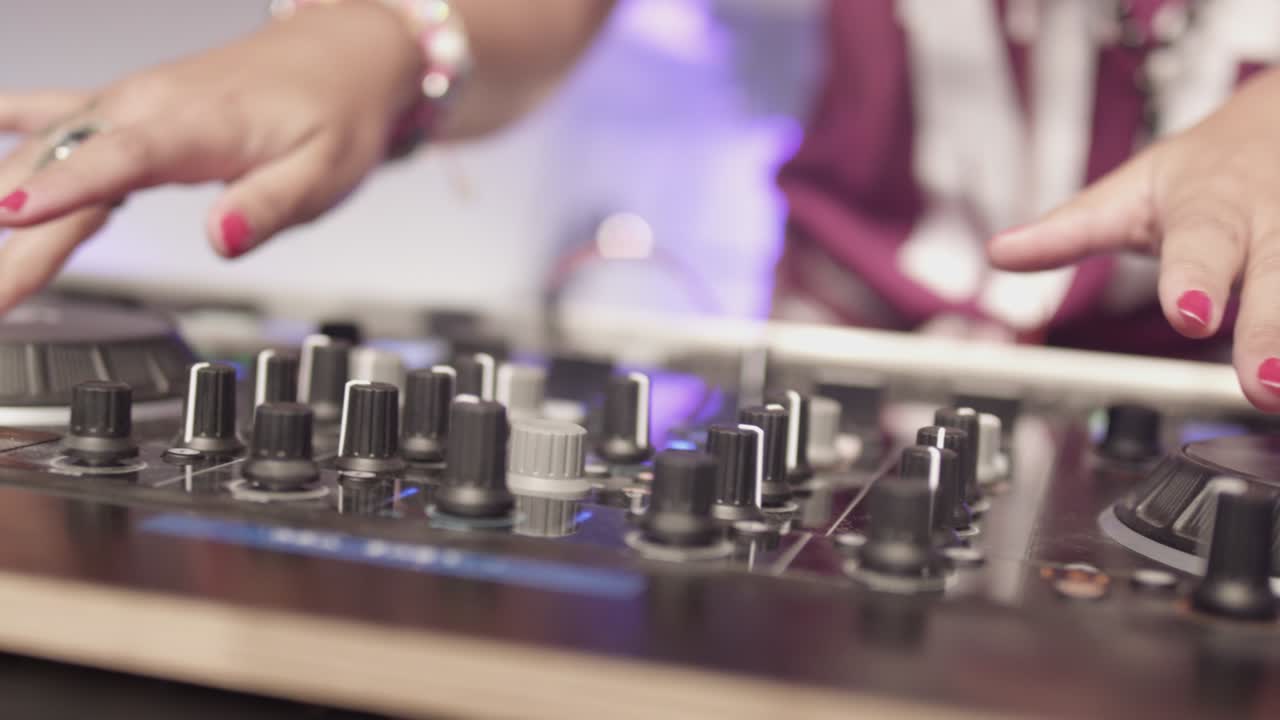 de izquierda a derecha de las manos de la mujer dj sintonizando el mezclador en una fiesta