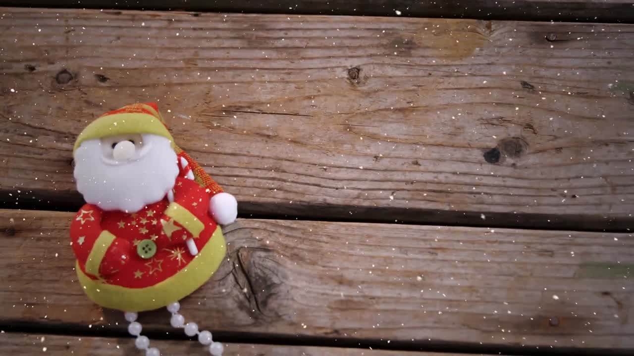 composición de video con nieve cayendo sobre el escritorio con la muñeca de santa